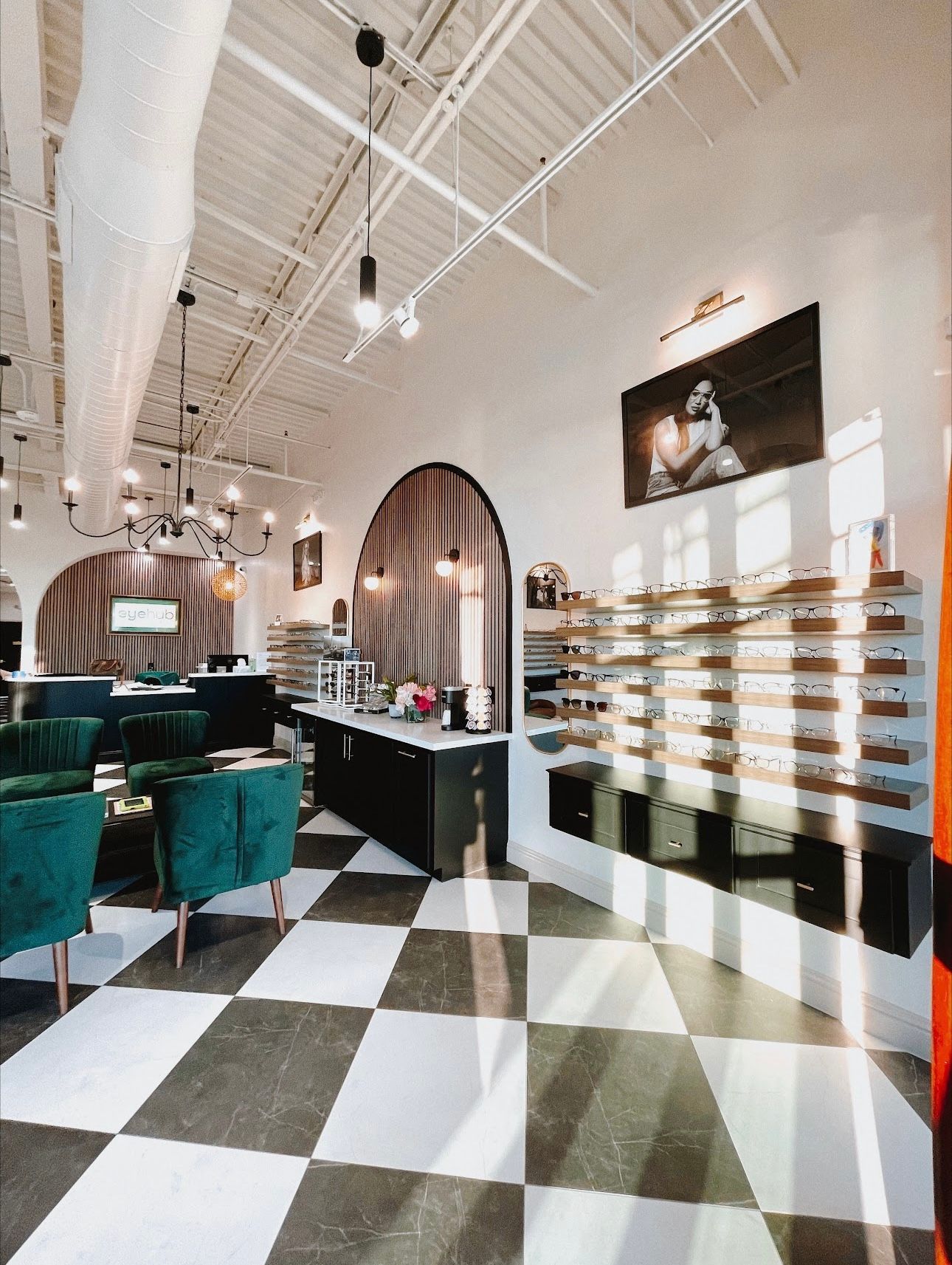 Optical shop interior with checkerboard floor, eyeglasses display, and seating area.