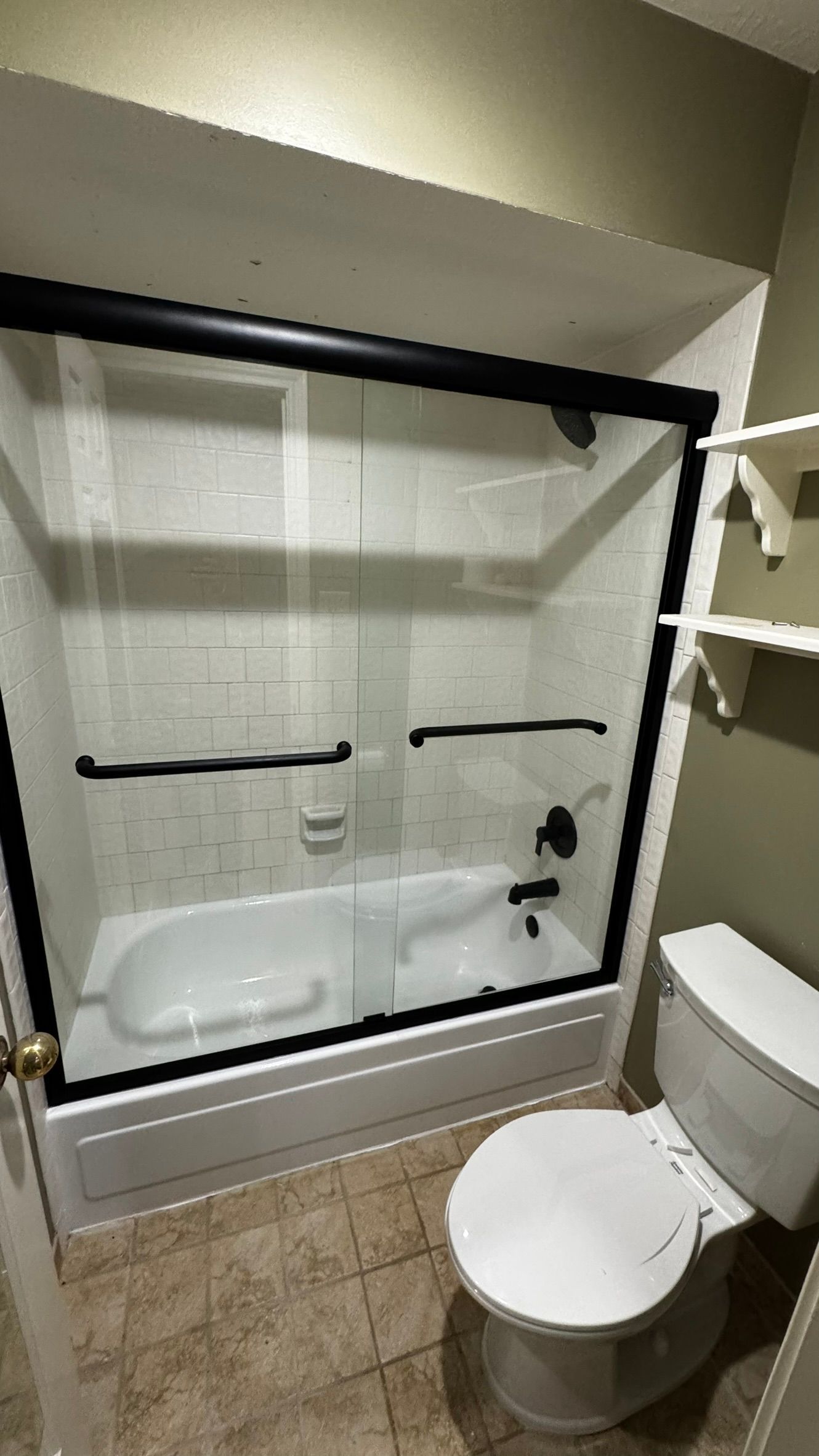 Small bathroom with a tub-shower, white curtain, beige tile floor, and toilet in the foreground.