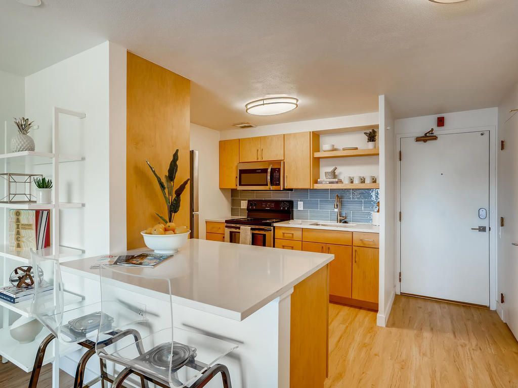 A kitchen with wooden cabinets and a white counter top