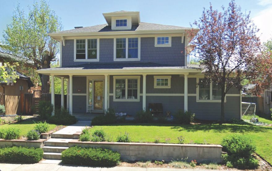 A blue house with white trim and a large porch