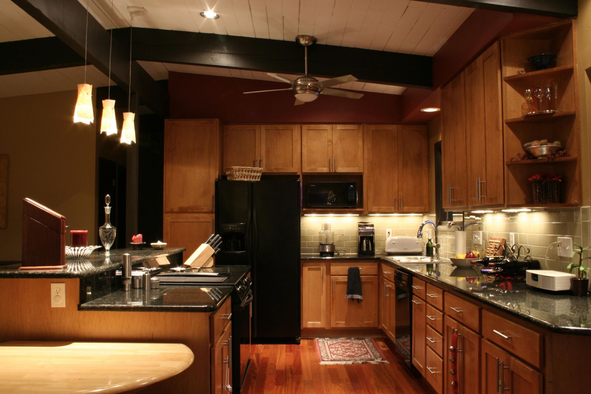 A kitchen with wooden cabinets and a black refrigerator