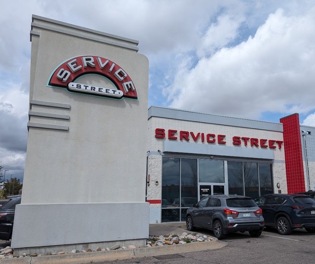 A service street building with cars parked in front of it
