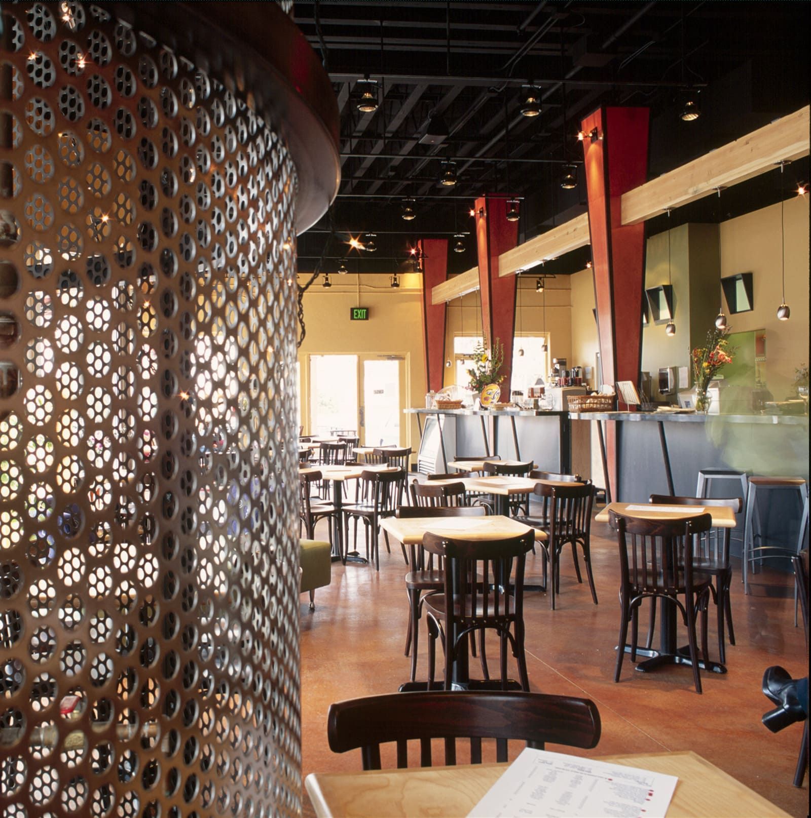 A restaurant with tables and chairs and a sign that says exit