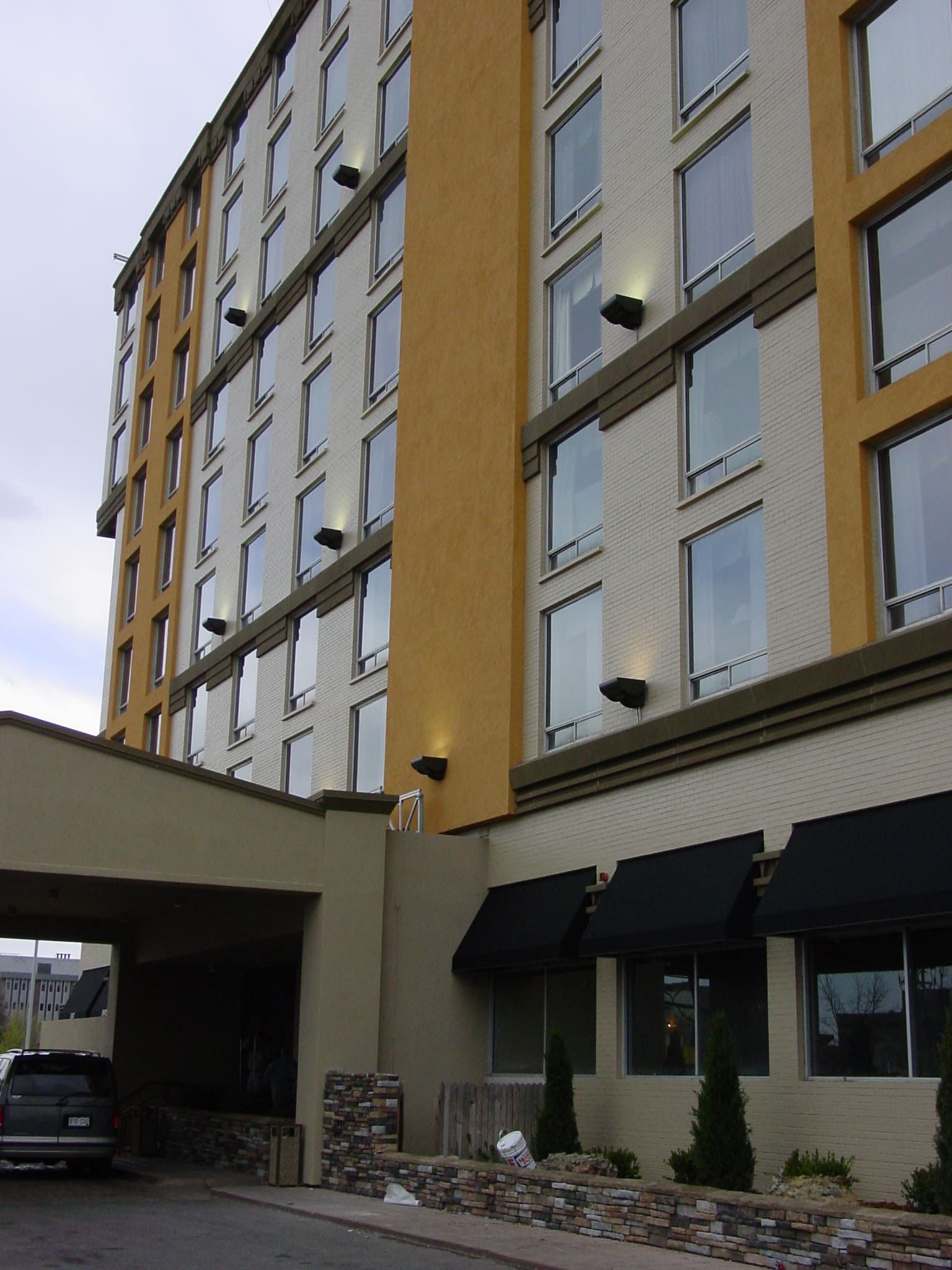 A car is parked in front of a large building