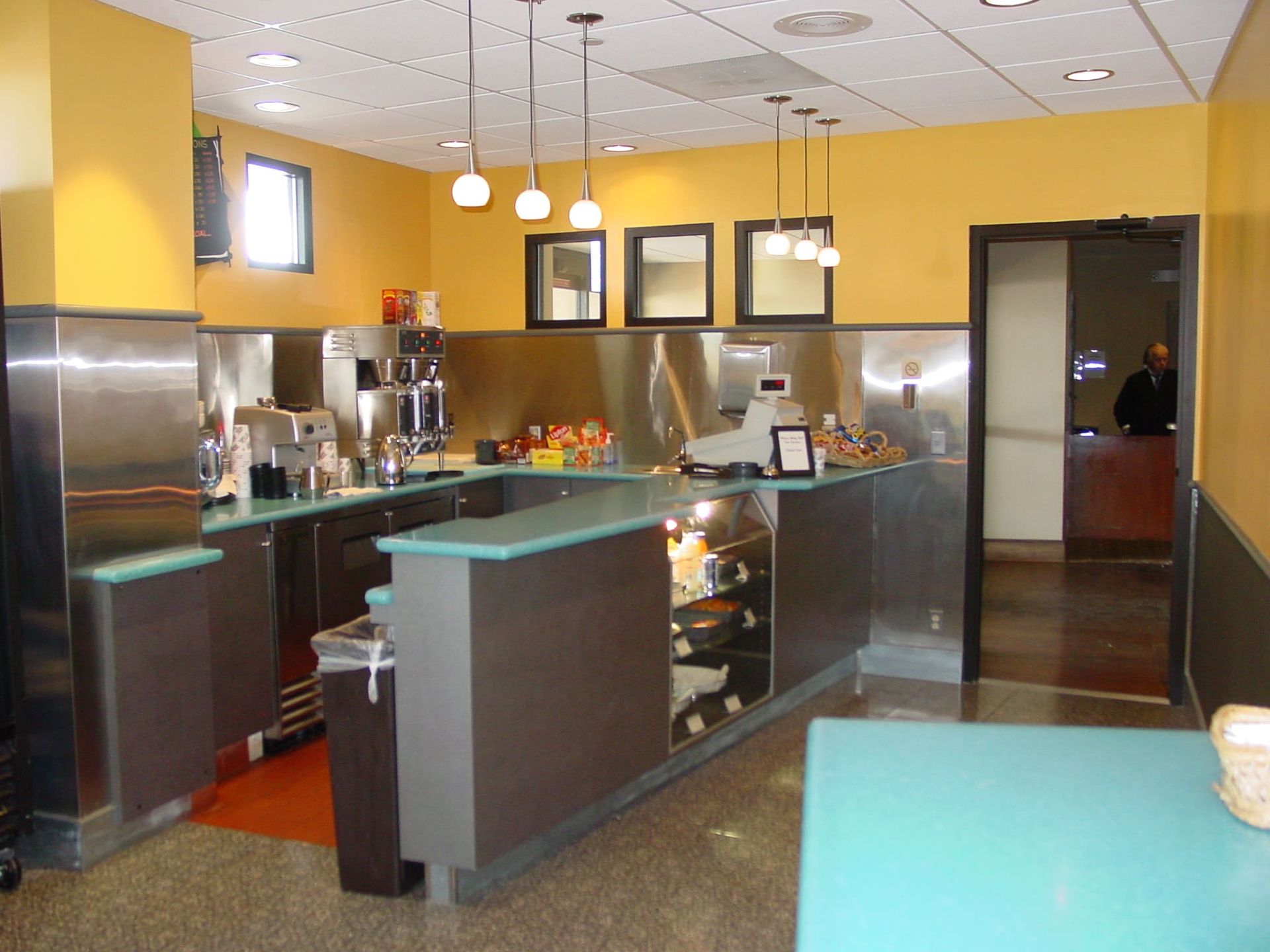 A kitchen with stainless steel appliances and yellow walls