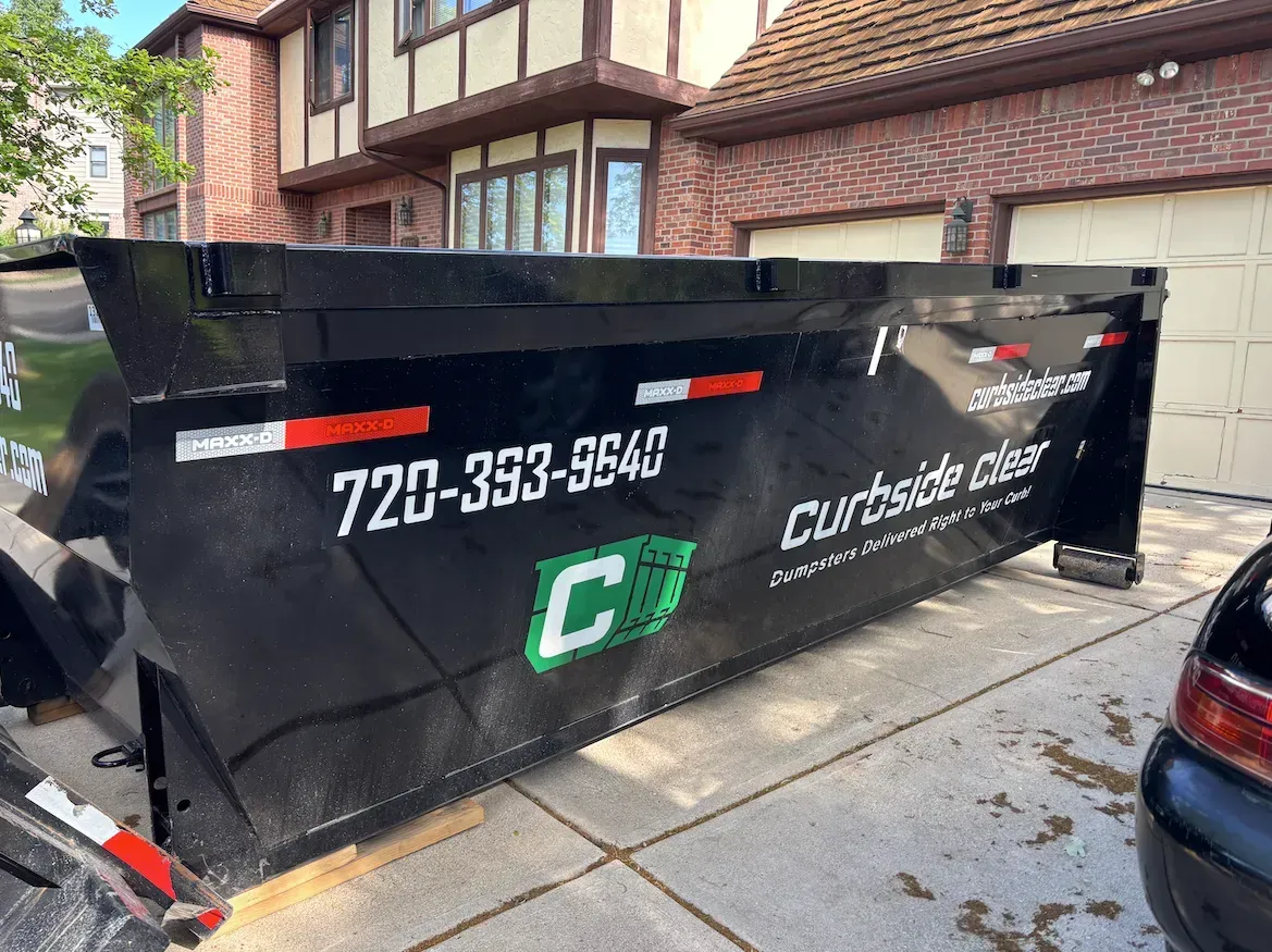 Curbside Clear roll-off dumpster placed in a residential driveway for a home cleanup project.