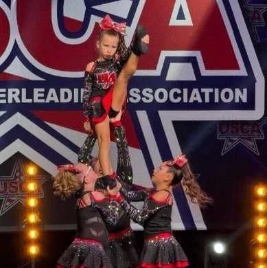 A group of cheerleaders are performing on a stage in front of a usca logo.