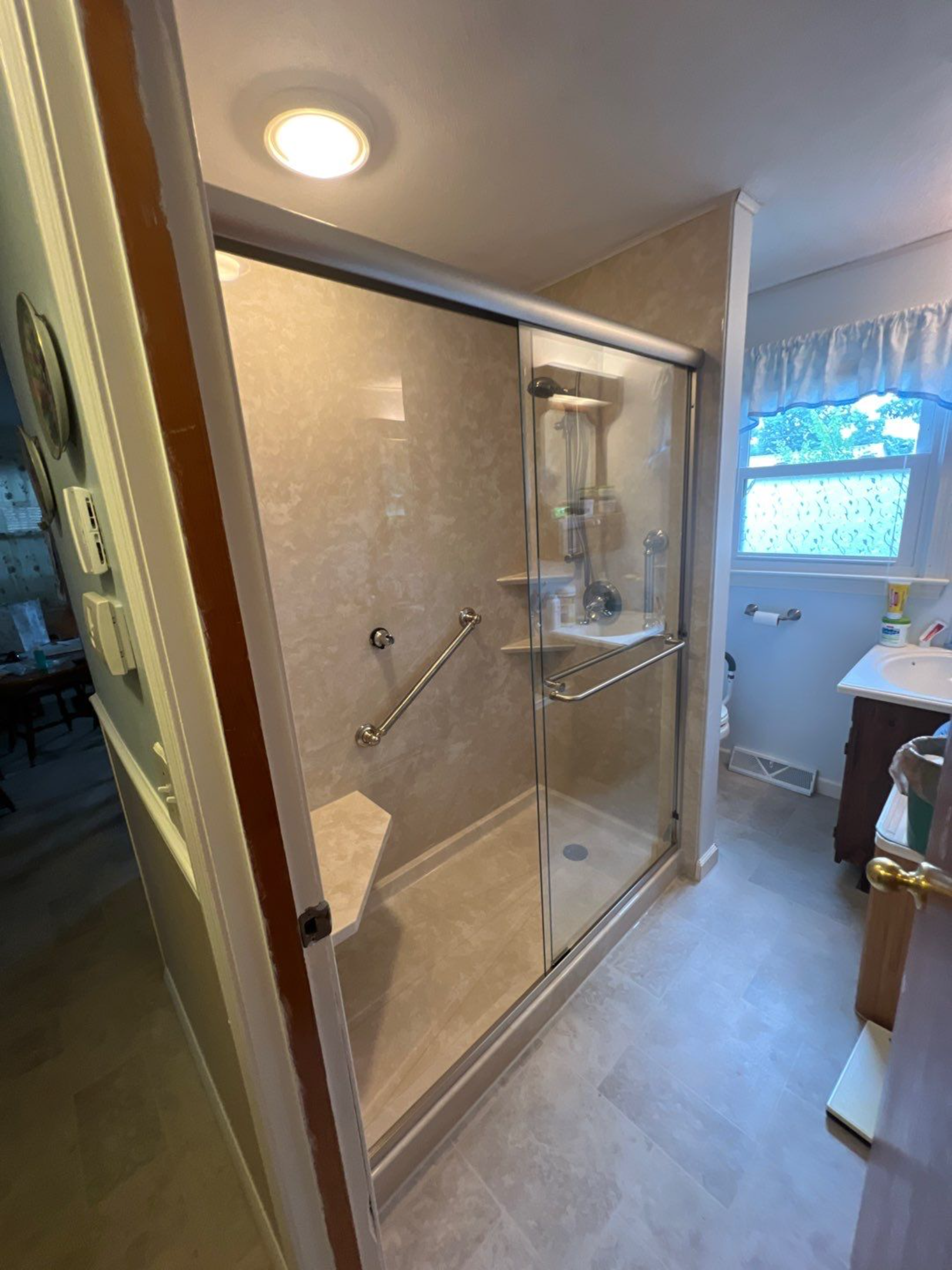 modern walk in master shower with corner seat