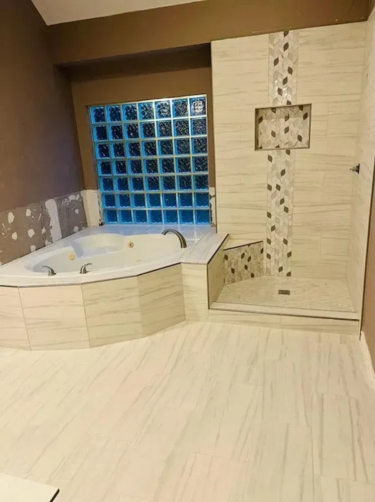 Bathroom remodel with jacuzzi tub, glass block window, and tiled shower.