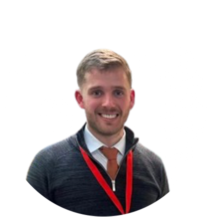 Man in gray sweater, orange tie, and red lanyard smiles.