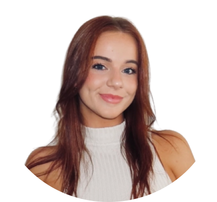 Woman with auburn hair smiles, wearing a white turtleneck in a round frame.
