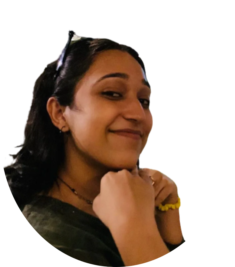 Woman with dark hair smiles, resting chin on hands.