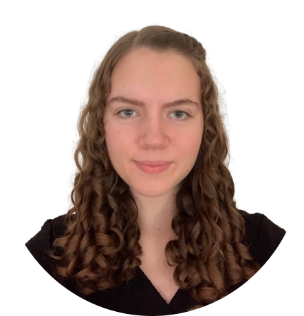 Woman with curly brown hair smiling, in front of a white background.
