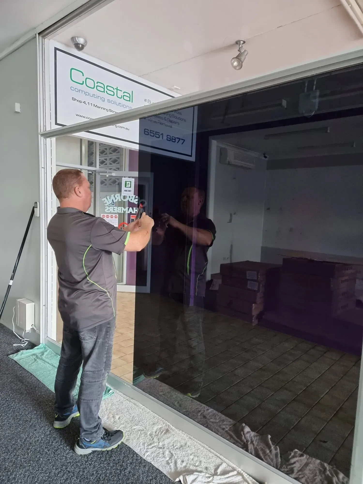 Man Applying Tint to a Window With a Squeegee — Awesome Window Tint In Wauchope, NSW