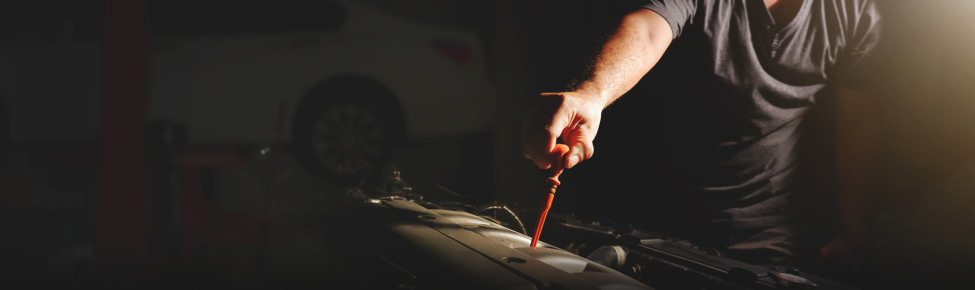 Person using a hand tool on a dark workbench in low light | The Recon Garage