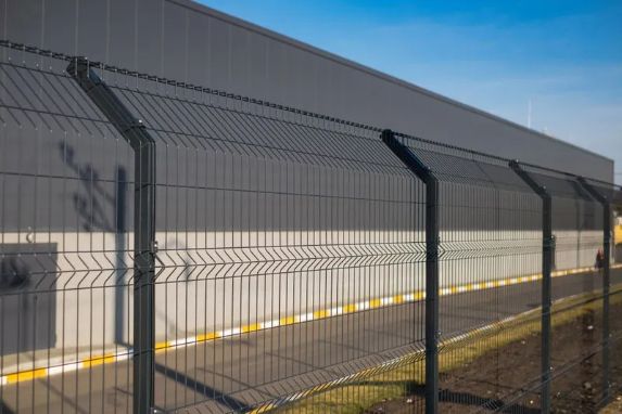 Black Mesh Fence With Grey Building and Yellow-bordered Walkway in the Background — Fencer Steve In South West Rocks, NSW