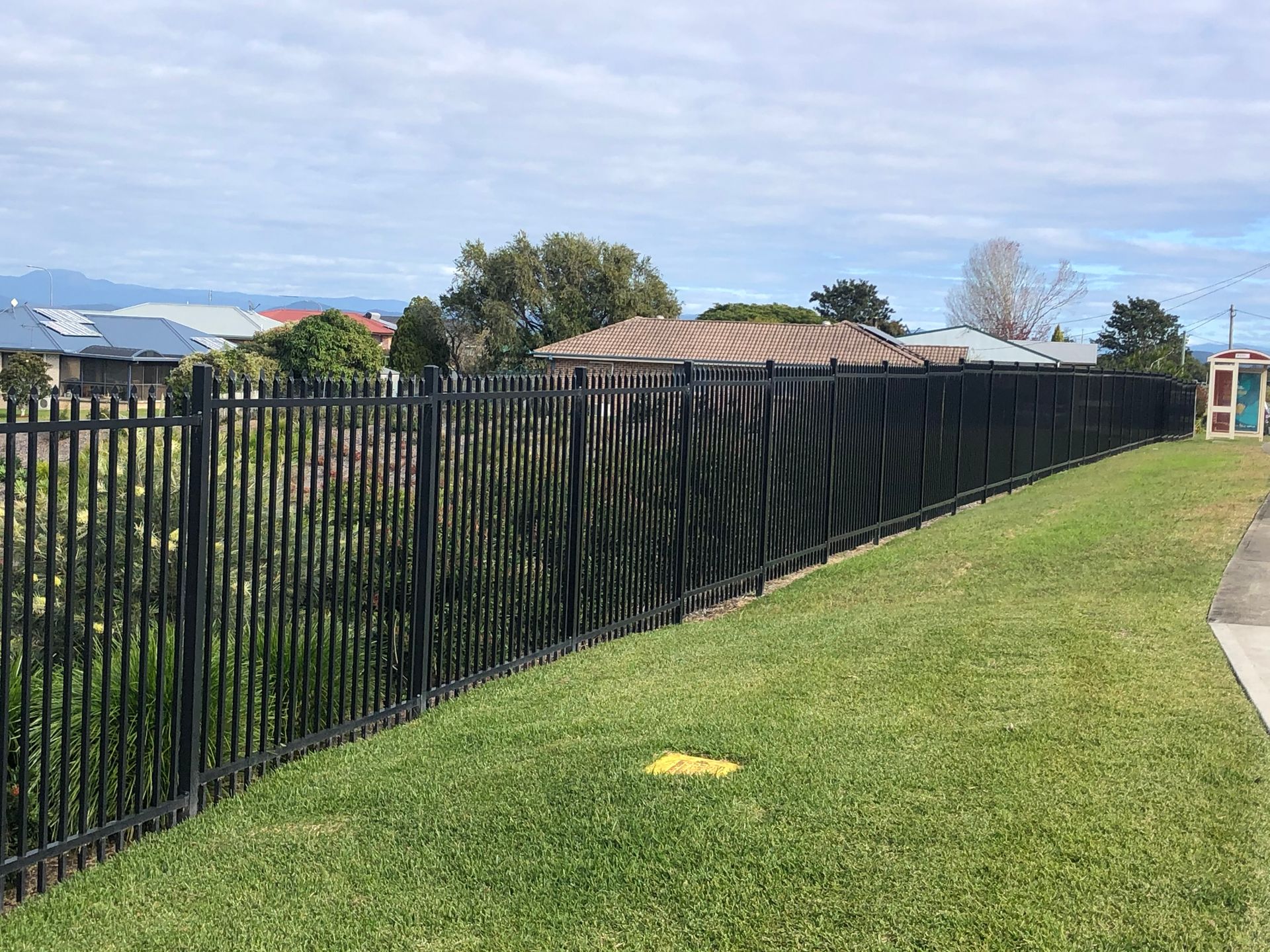 Black Metal Fence Along a Grassy Hill, Separating Properties — Fencer Steve in Wauchope, NSW