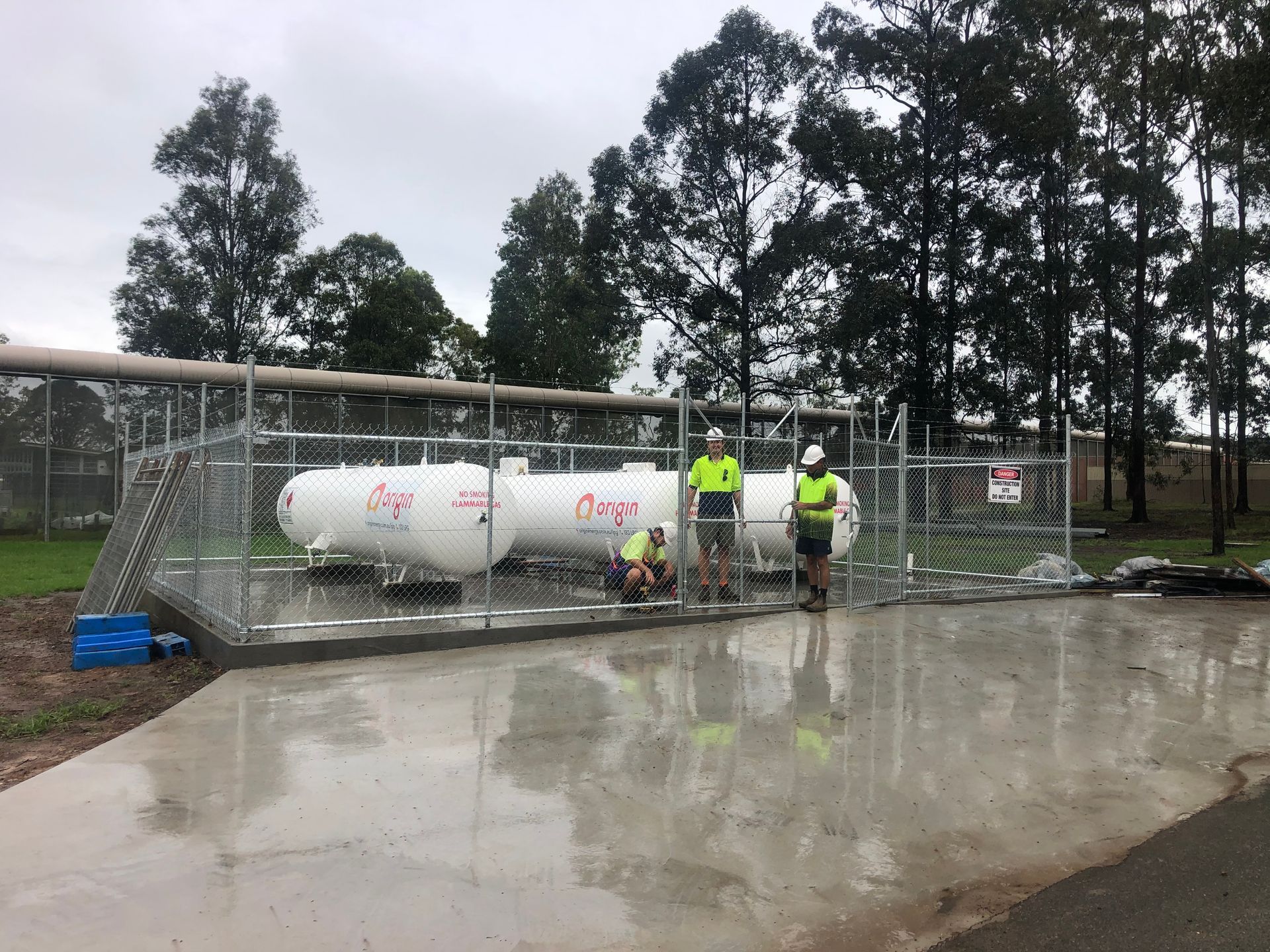Workers Near Fenced White Gas Tanks at a Facility — Fencer Steve In South West Rocks, NSW