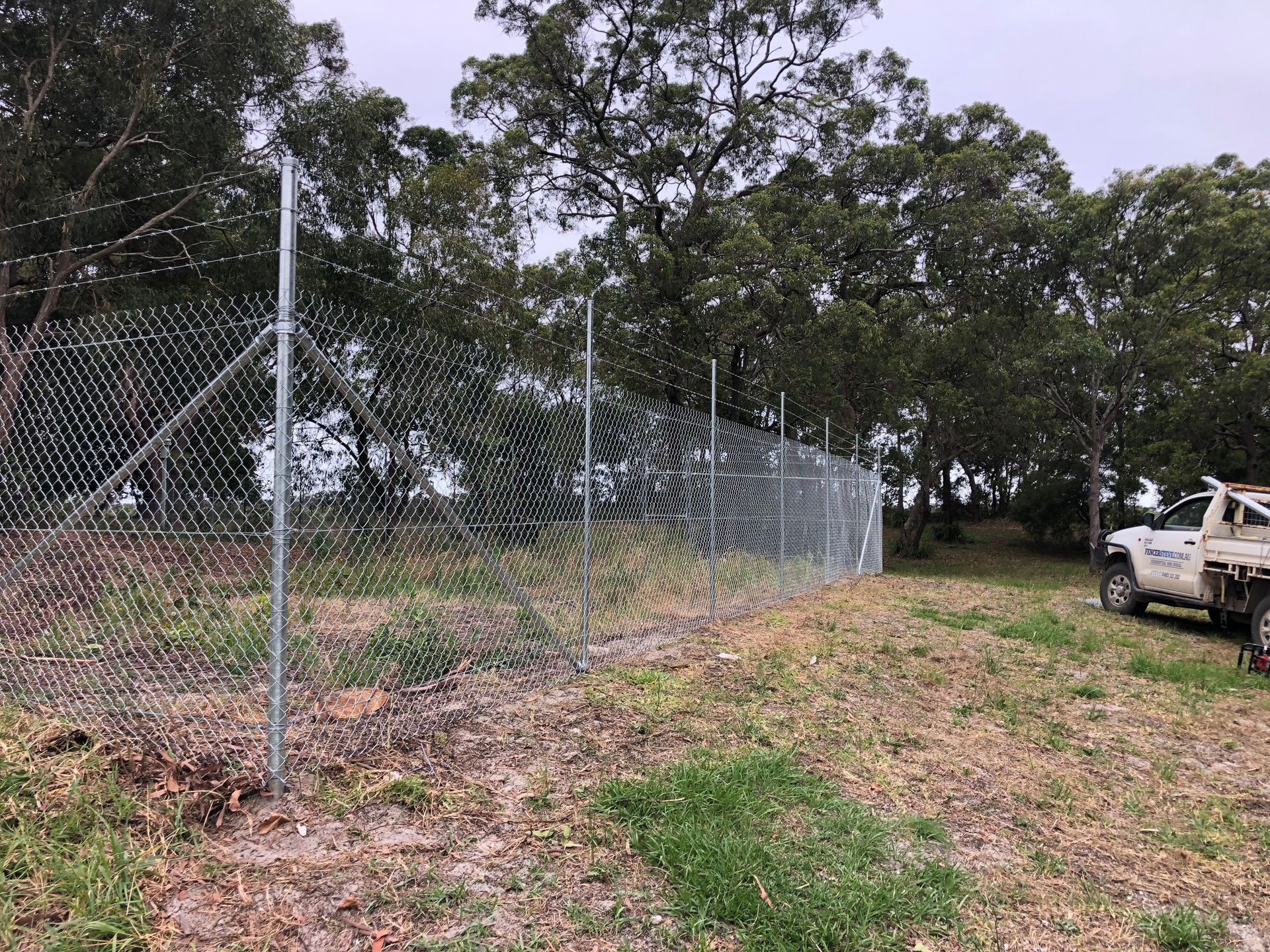 Chain-link Fence With a Blurred View of a Green Field, Soccer Goal — Fencer Steve in Temagog, NSW