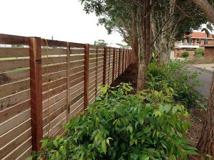 Wooden Horizontal Slat Fence Along a Street Lined With Trees and Bushes — Fencer Steve In Temagog, NSW