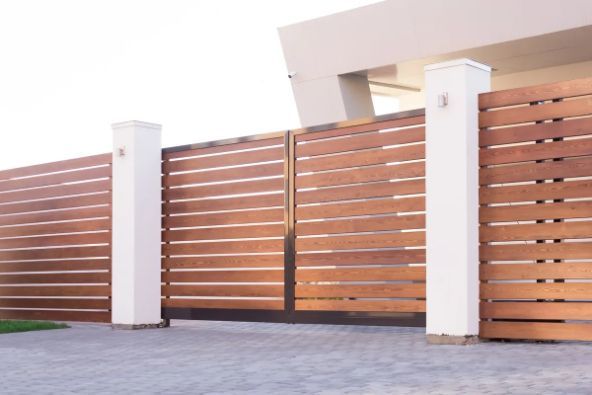 Wooden Driveway Gate With Horizontal Slats, Flanked by White Pillars — Fencer Steve In Crescent Head, NSW