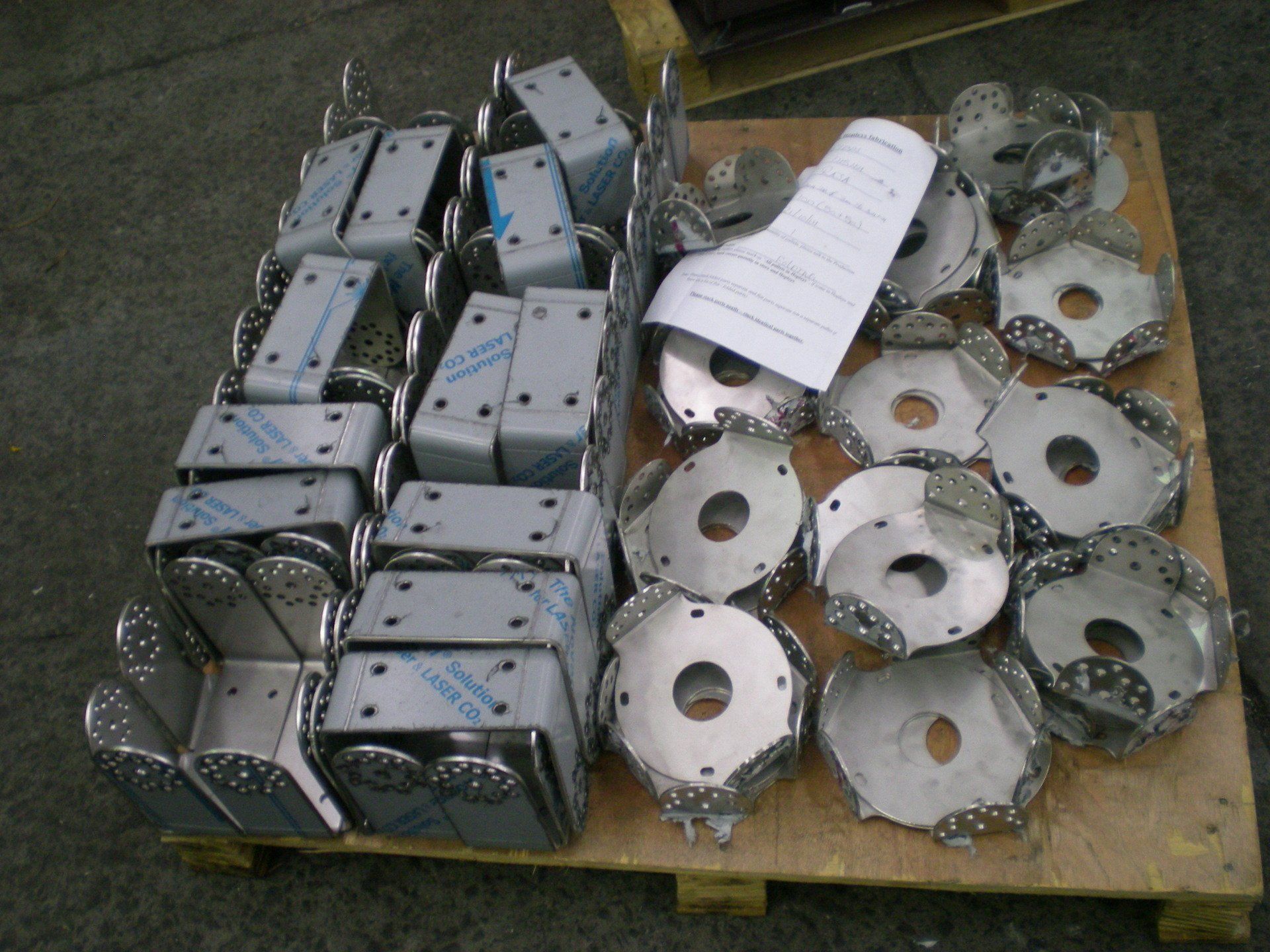 Pallet of shiny metal components, likely for industrial use.