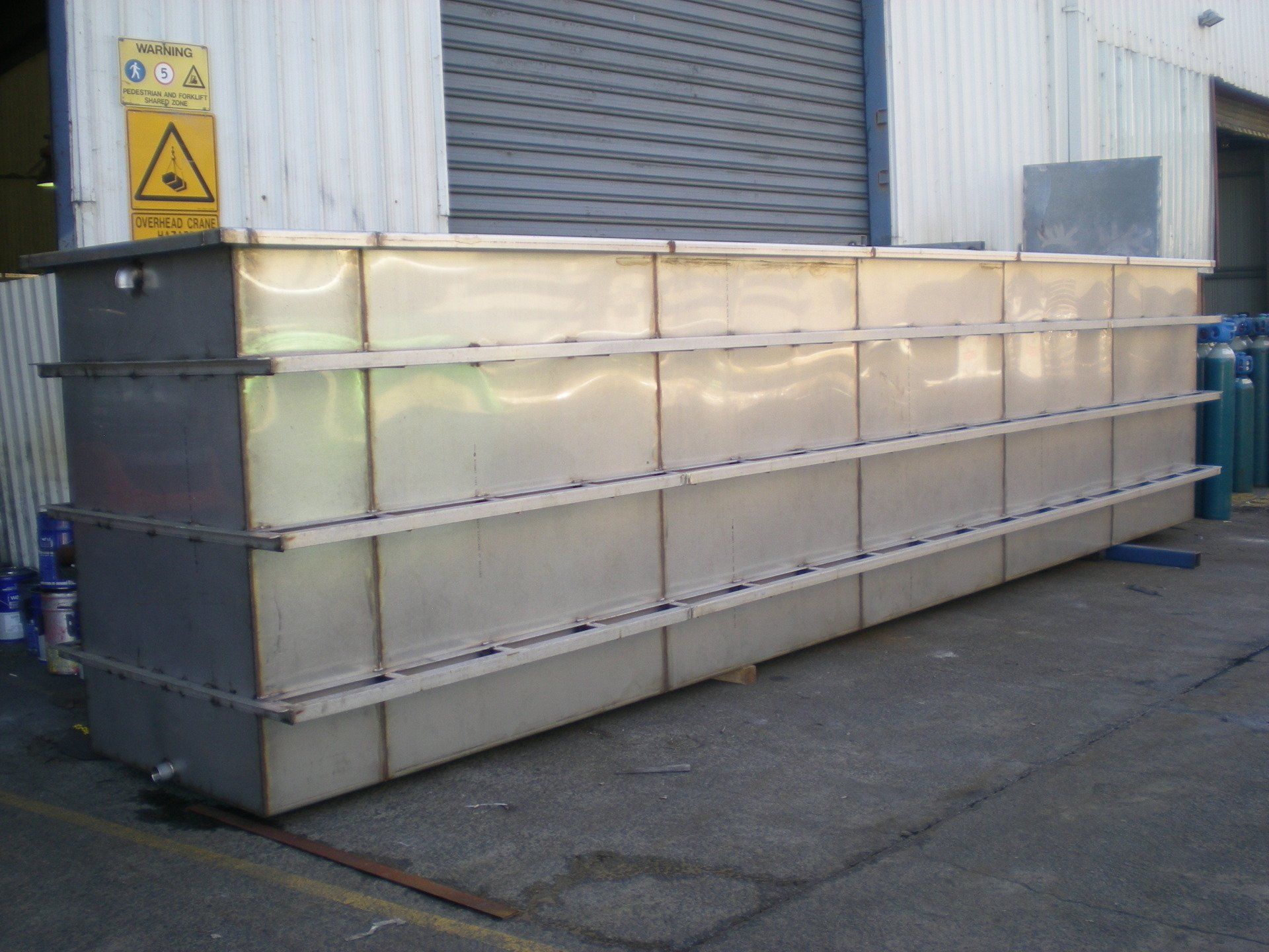 A long, rectangular metal tank composed of multiple horizontal sections, likely for industrial use.