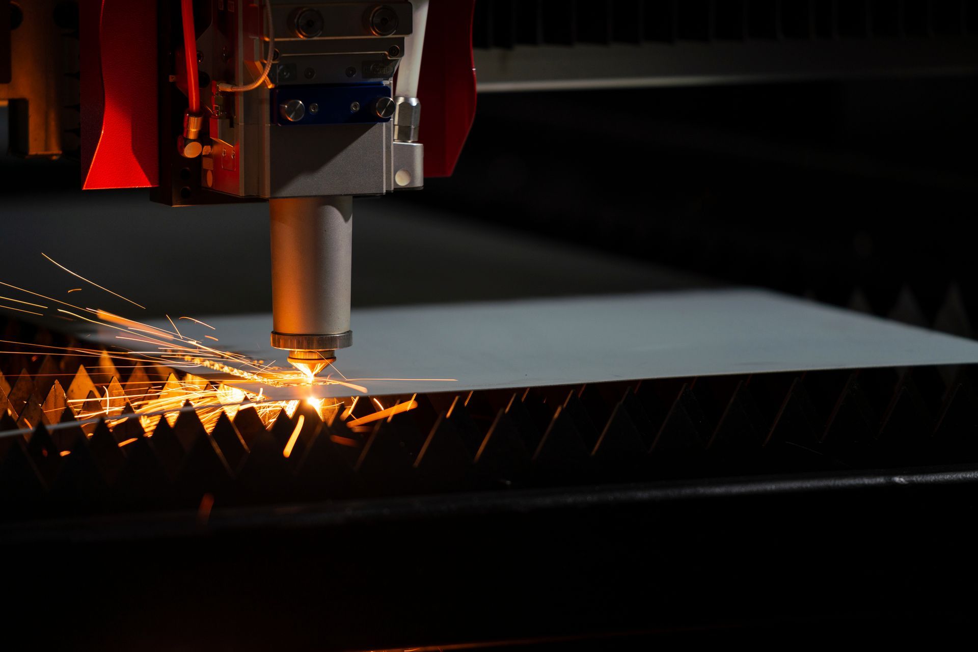 Laser cutting machine emitting sparks while cutting metal sheet. Laser cutting machine emitting sparks while cutting metal sheet.