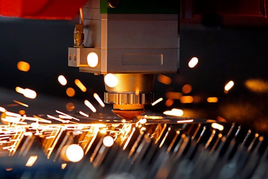 High-precision Metal Laser Cutting process with sparks flying as a CNC machine cuts through steel.