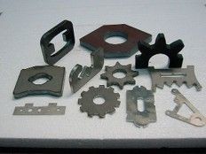A collection of metal parts and tools arranged flat, showcasing various shapes and sizes