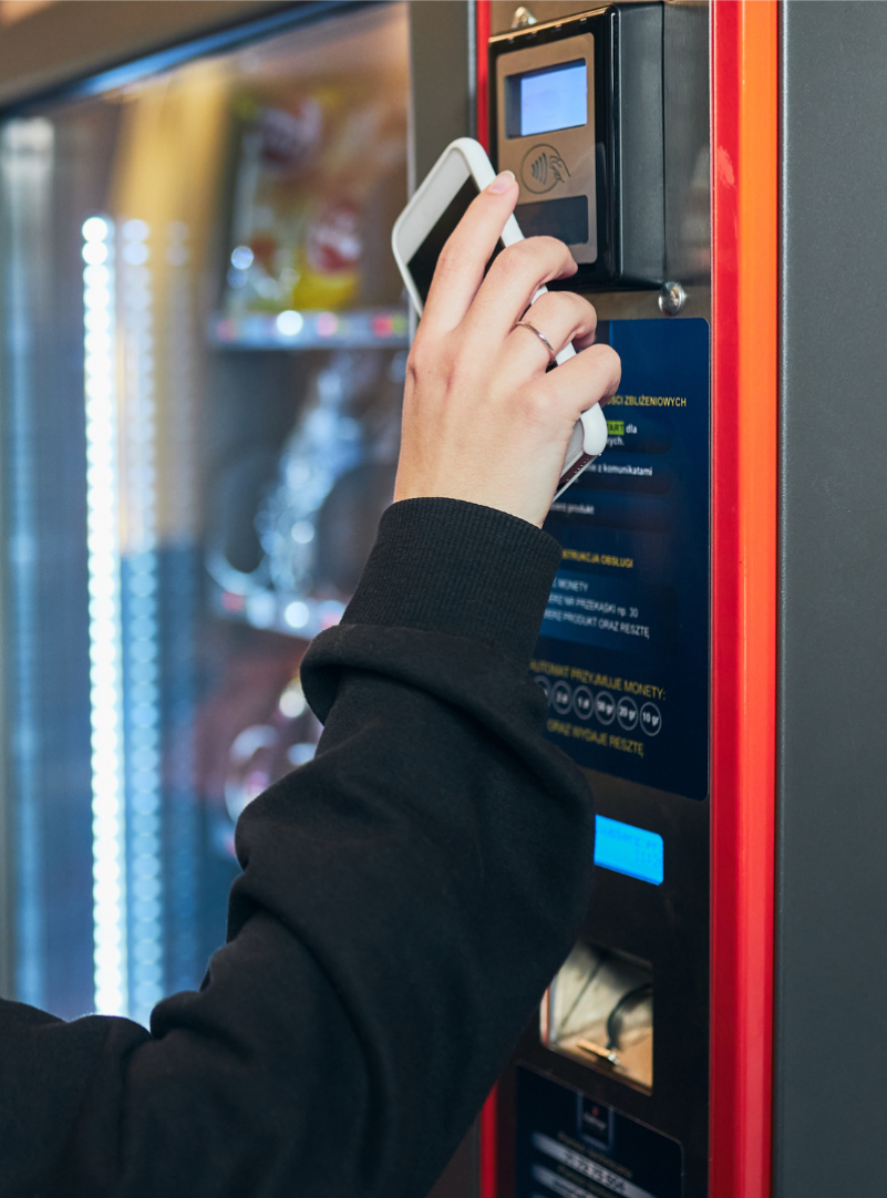 Person using a card at a vending machine payment terminal