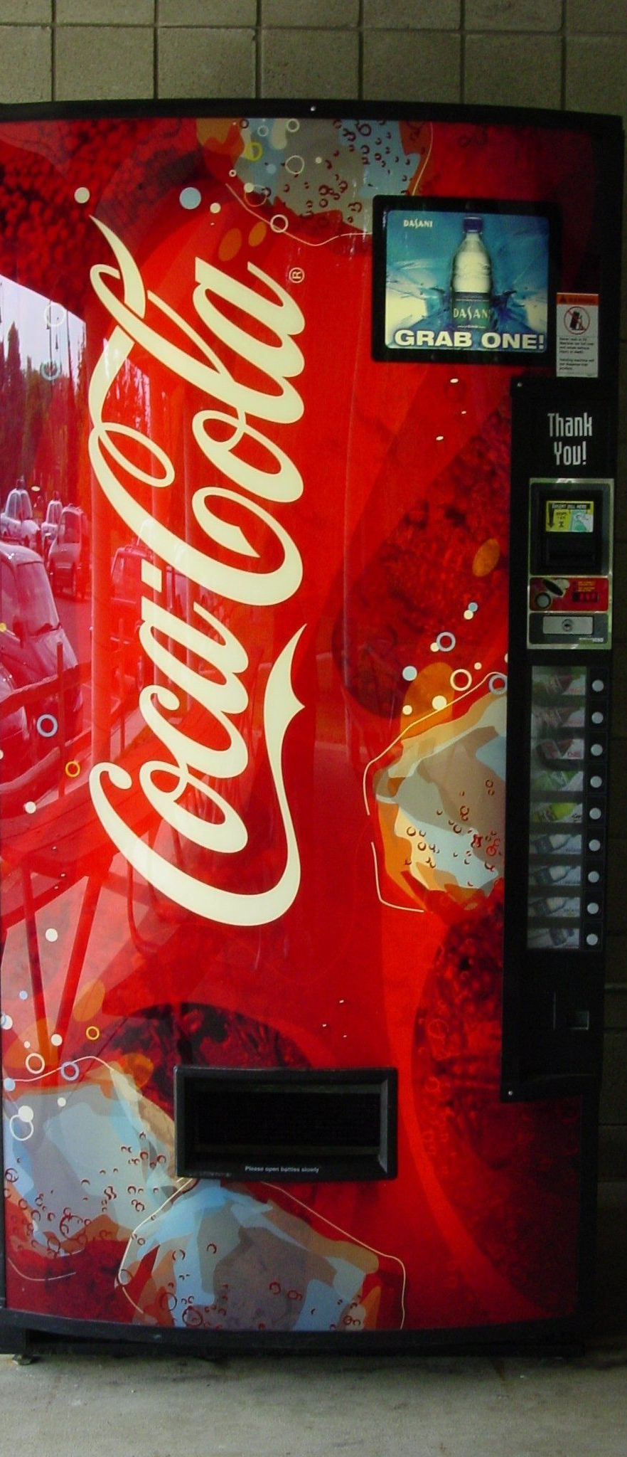 Red Coca-Cola vending machine with white logo against a tiled wall