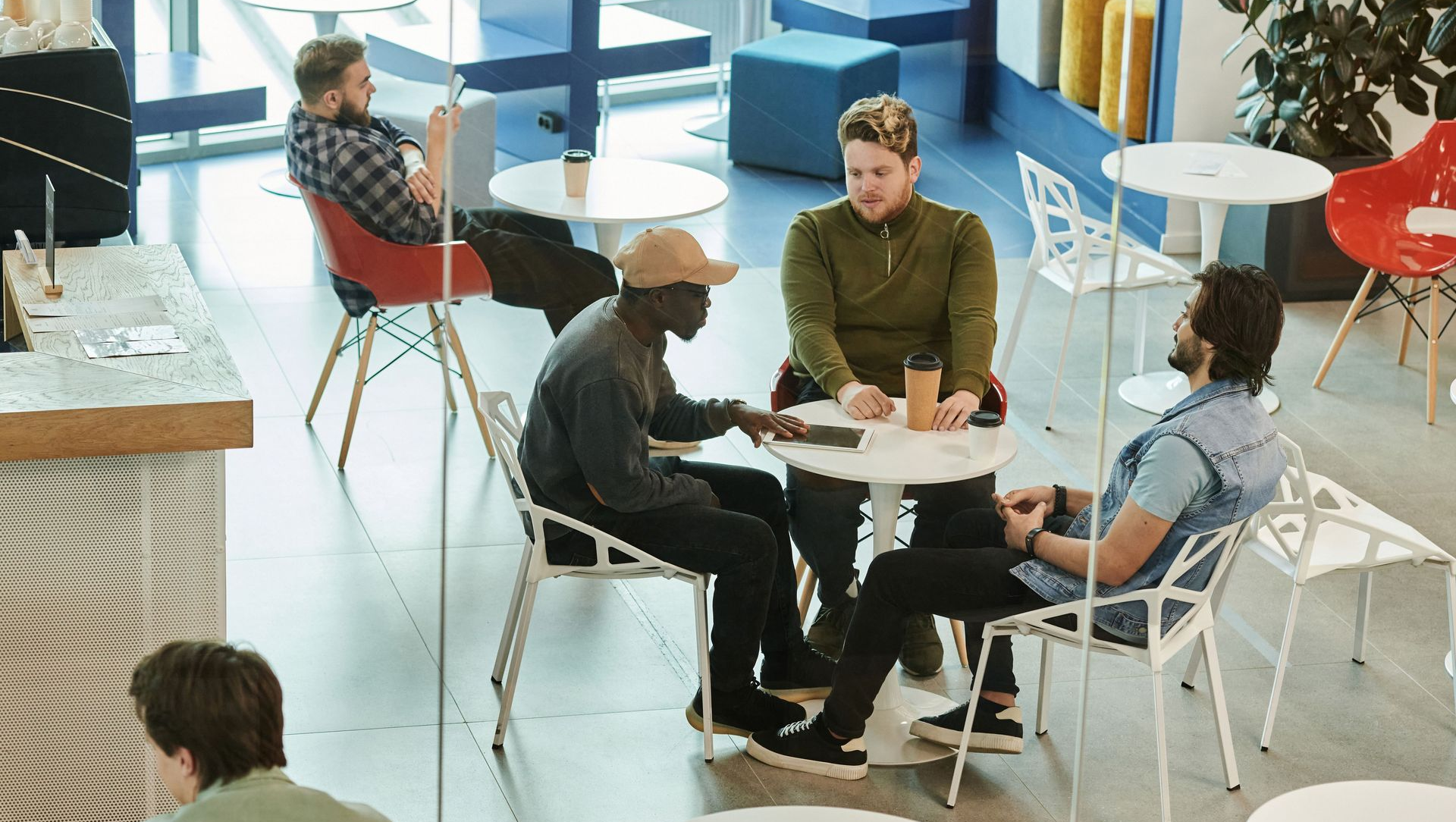 People sitting around a small table in a bright modern office lounge