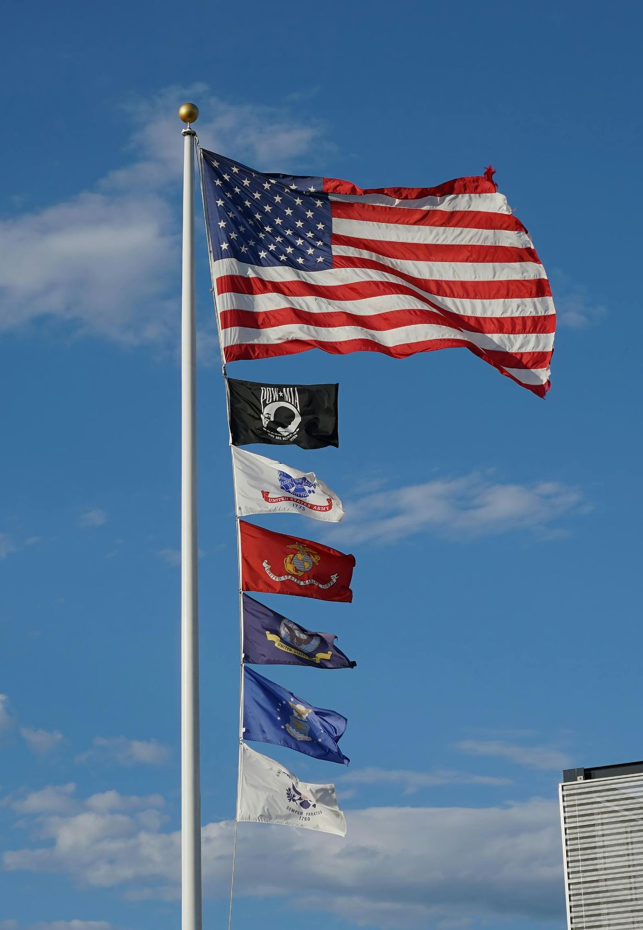 U.S. flag above a row of smaller flags waving against a blue sky