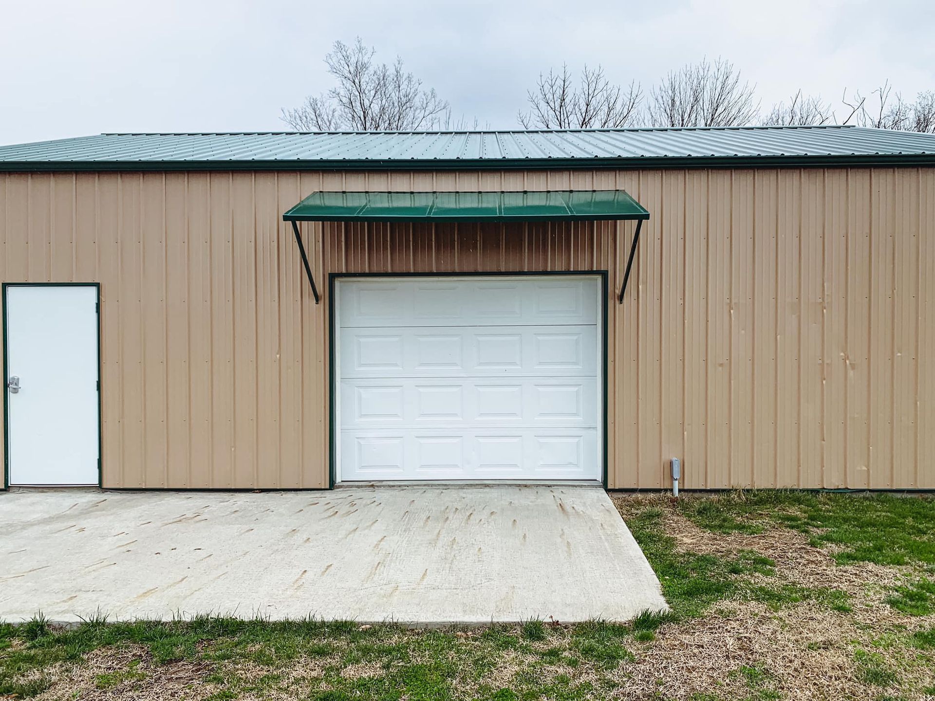 A Garage With a Green Metal Roof & Awning. Get in Touch With Mid-Missouri's Merit Welding for More!