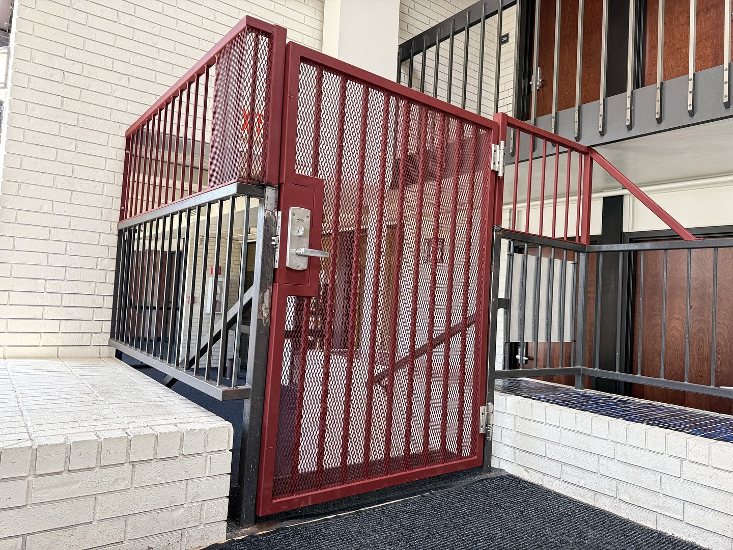 A Red Steel Gate, Serviced By Merit Welding in Central Missouri. Improve Your Commercial Structure
