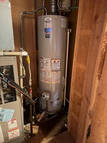 Person working on a wall-mounted boiler, opening the panel to access the internal components.