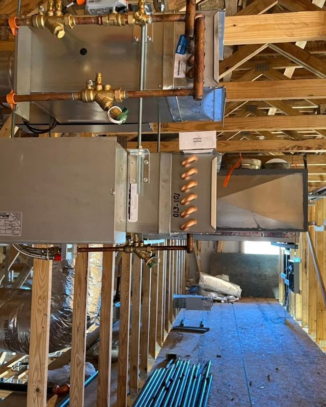 HVAC system installed in an attic; copper pipes and metal components are visible.