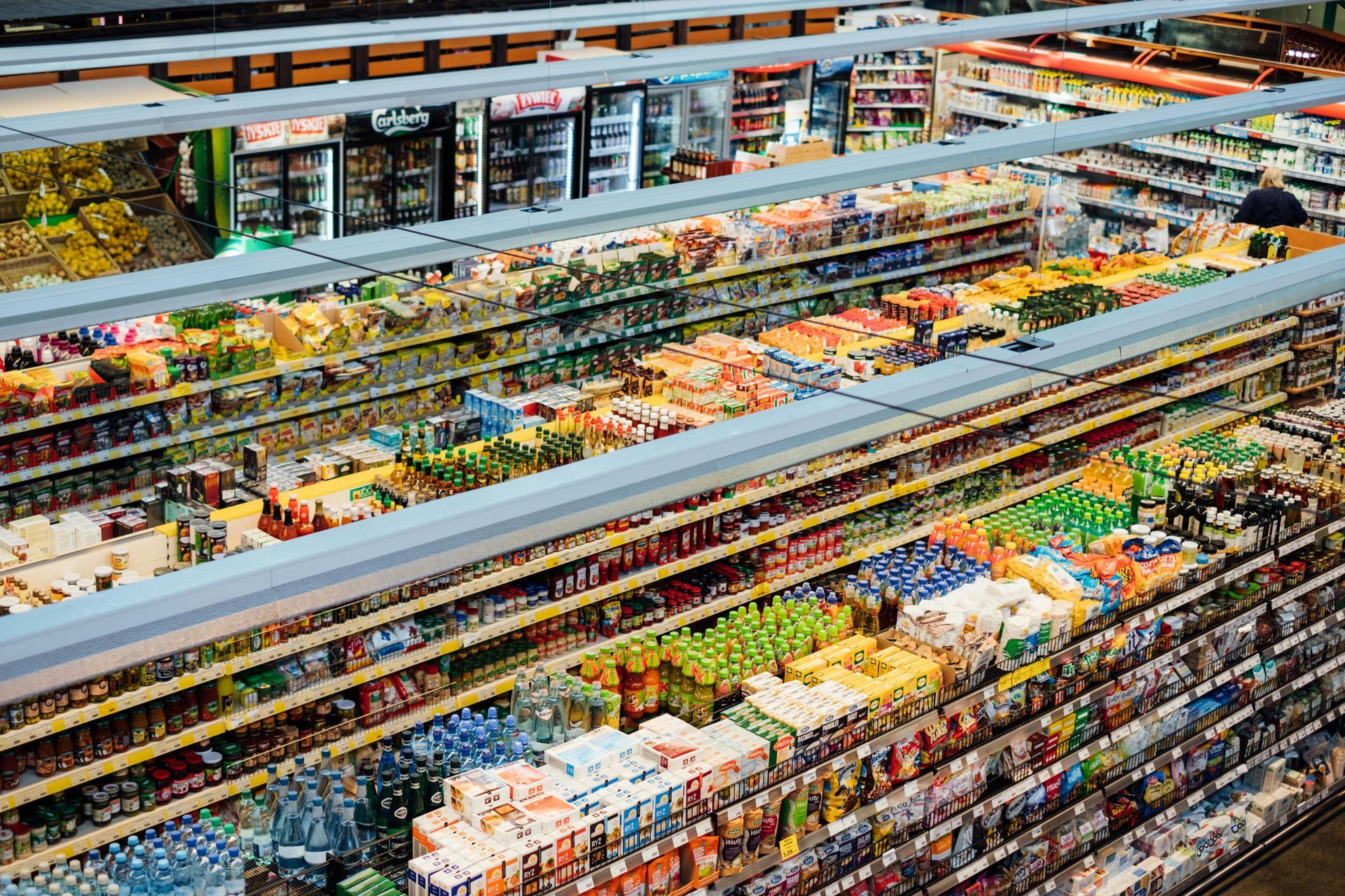 Aerial view of a colorful supermarket produce section with rows of fruits, vegetables, and packaged goods