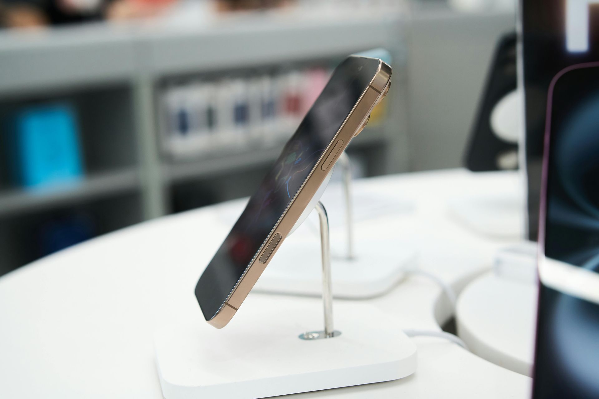 Smartphone on a display stand in a retail store, shown at an angle on a white counter.