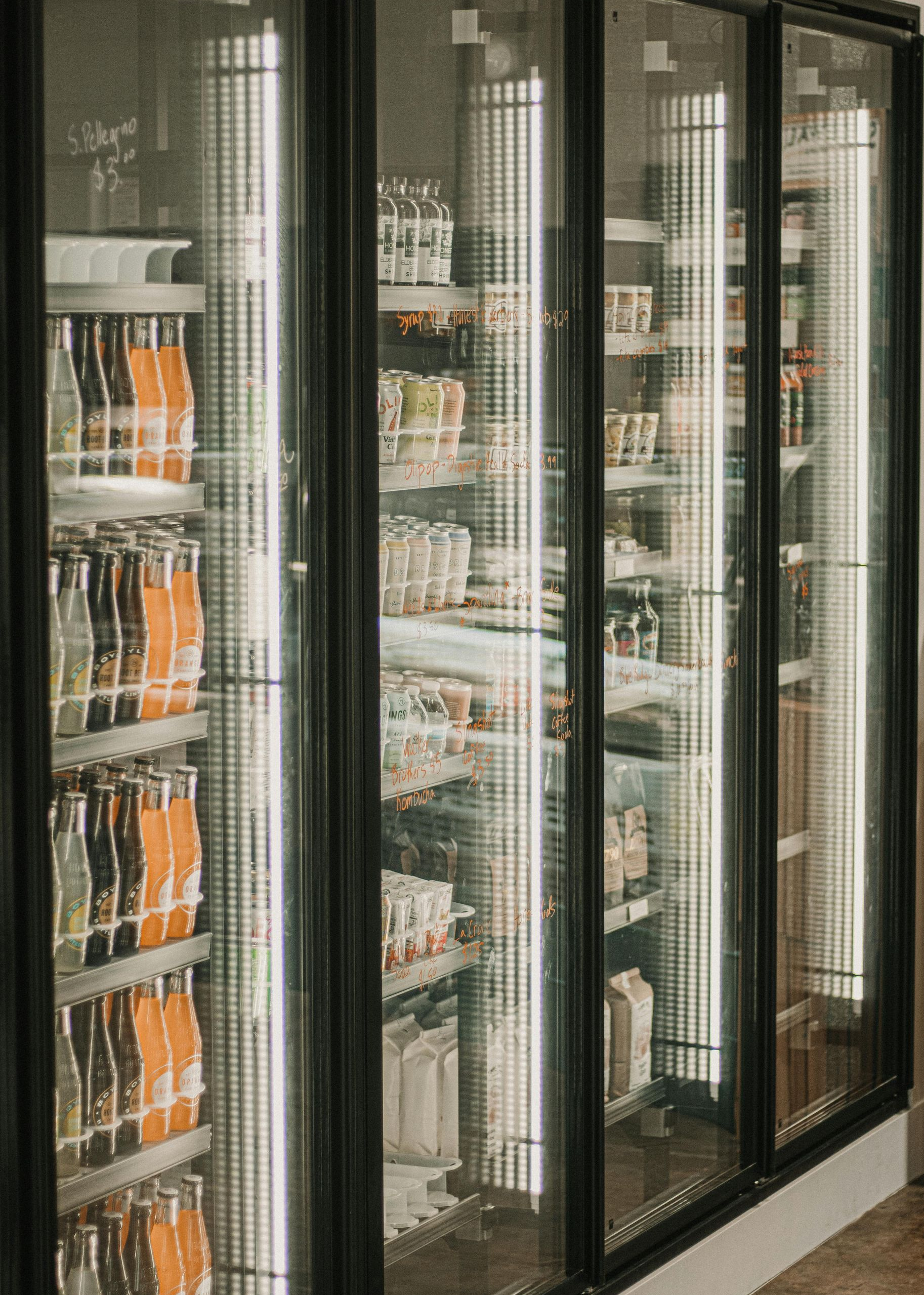 Glass-doored refrigerated display case stocked with drinks and packaged items in a store