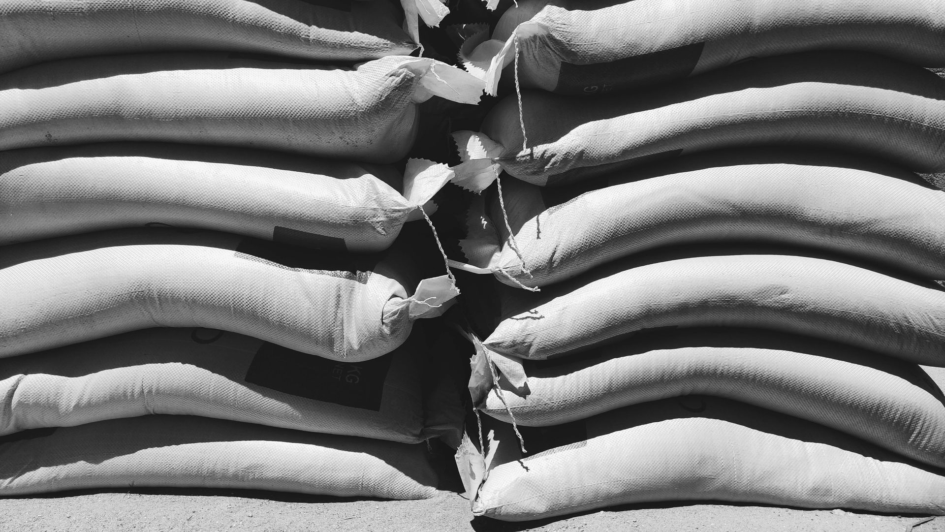 Stacked sandbags blocking a narrow opening, forming a protective barrier.