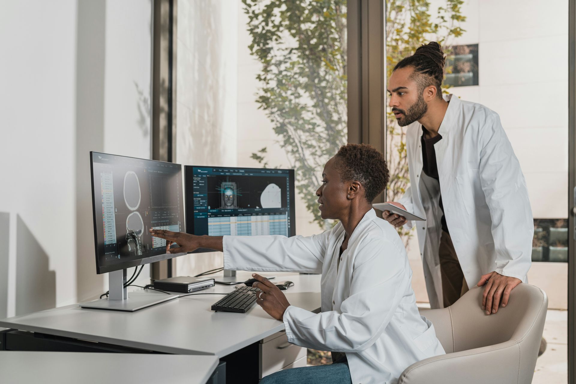 Two medical professionals are looking at a computer screen.