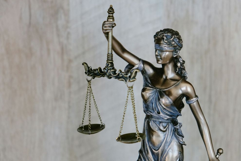 A statue of a blindfolded woman holding a scale of justice.