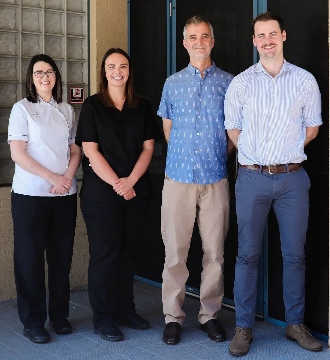 Four People Dressed in Casual and Professional Attire — Maitland Dental Care in Maitland, NSW