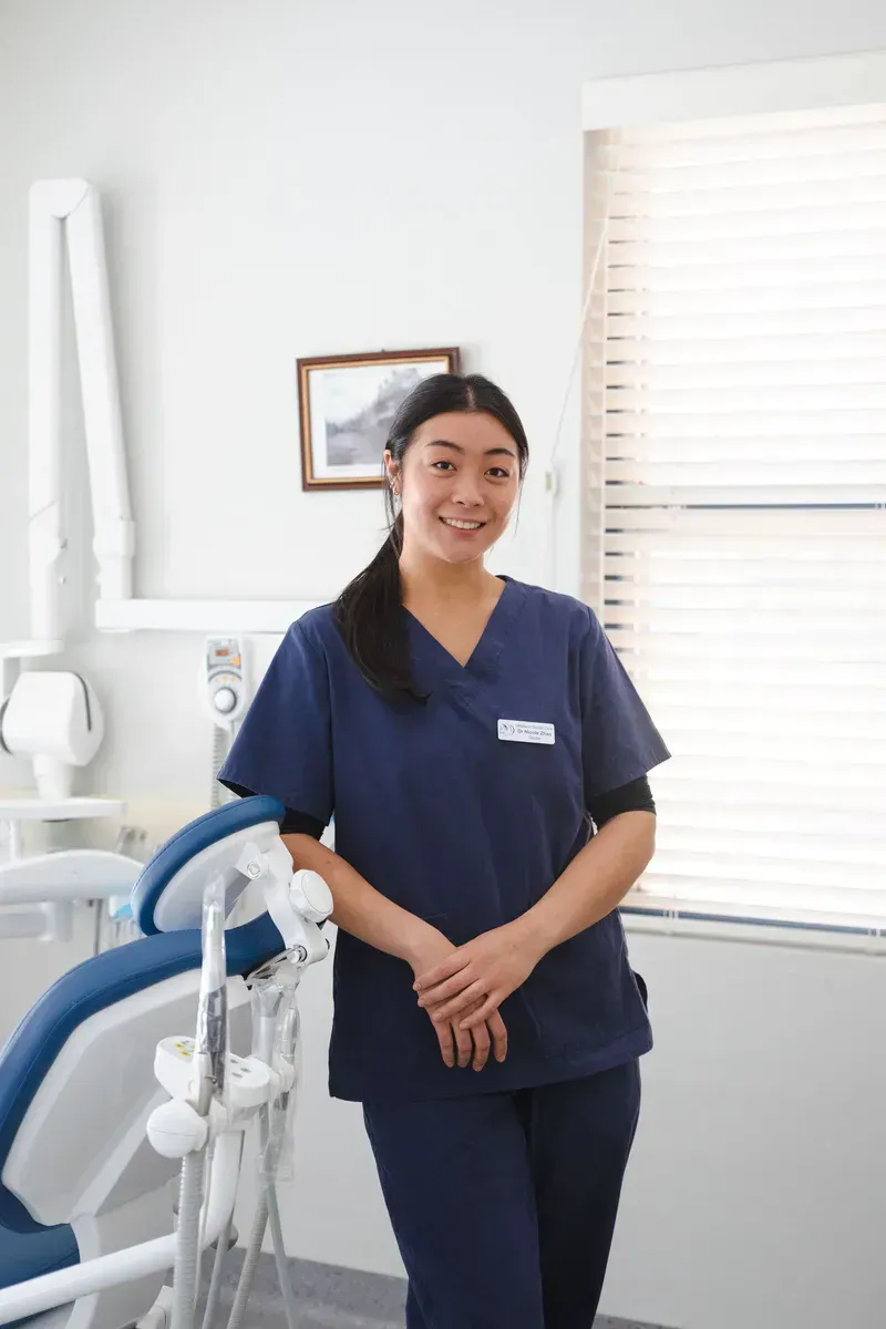 Woman in Blue Scrubs Smiles in a Dental Office — Maitland Dental Care in Maitland, NSW