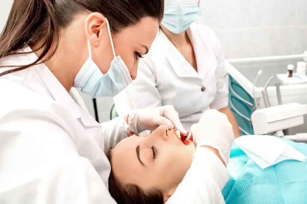 Dentist Examining Patient Teeth With Assistant — Maitland Dental Care in Maitland, NSW