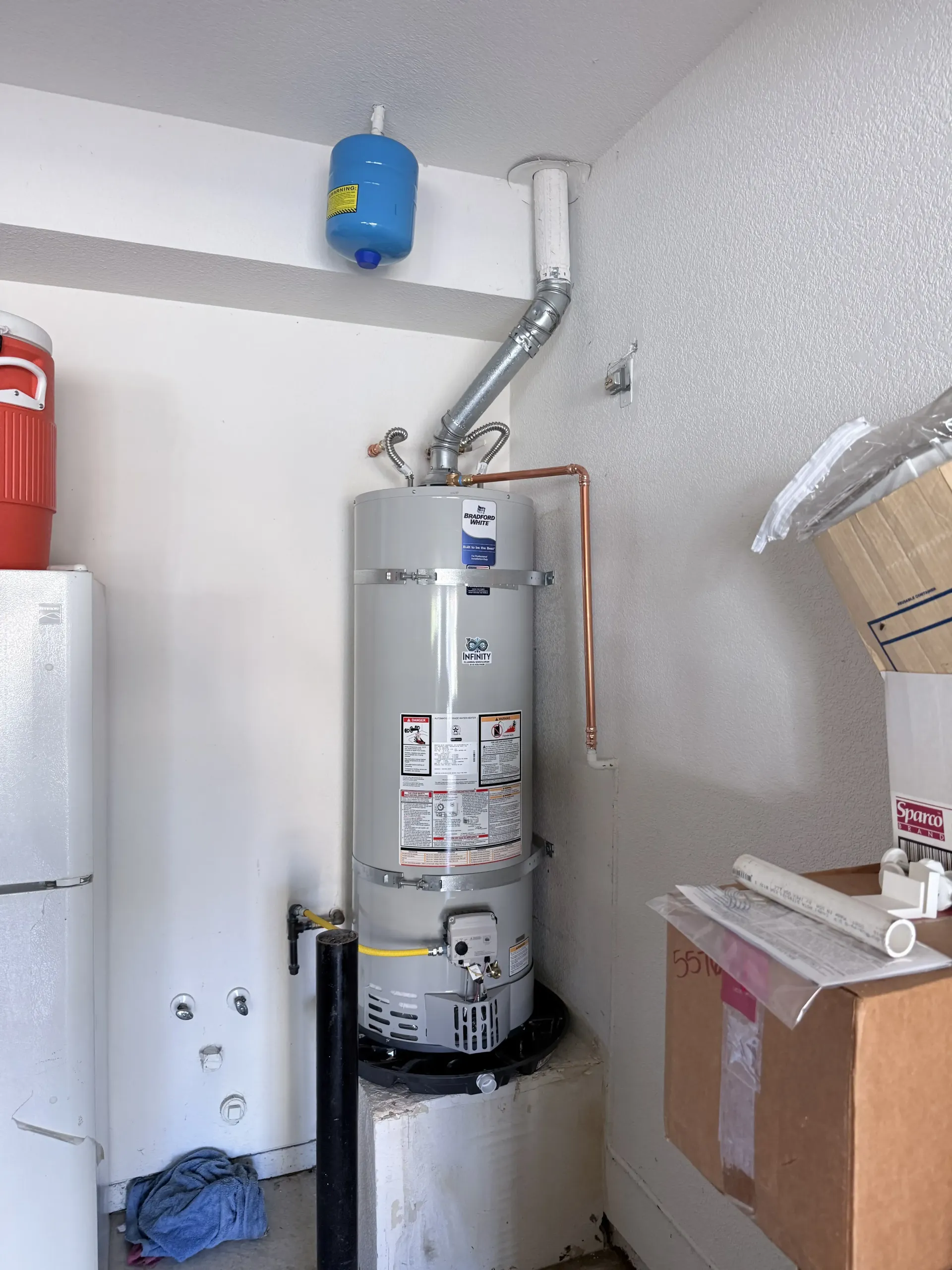 A man is holding a notebook and a pen while working on a boiler.