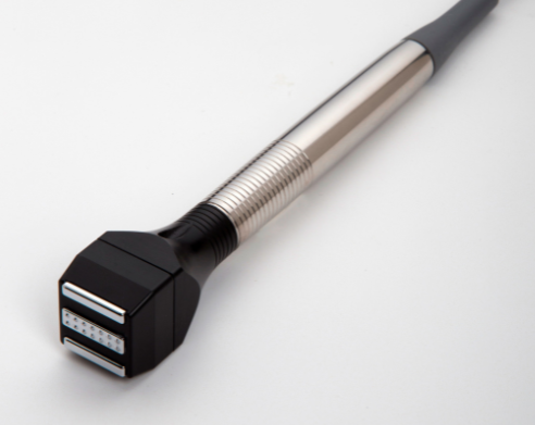 Medical device with silver and black components, angled on a white surface.