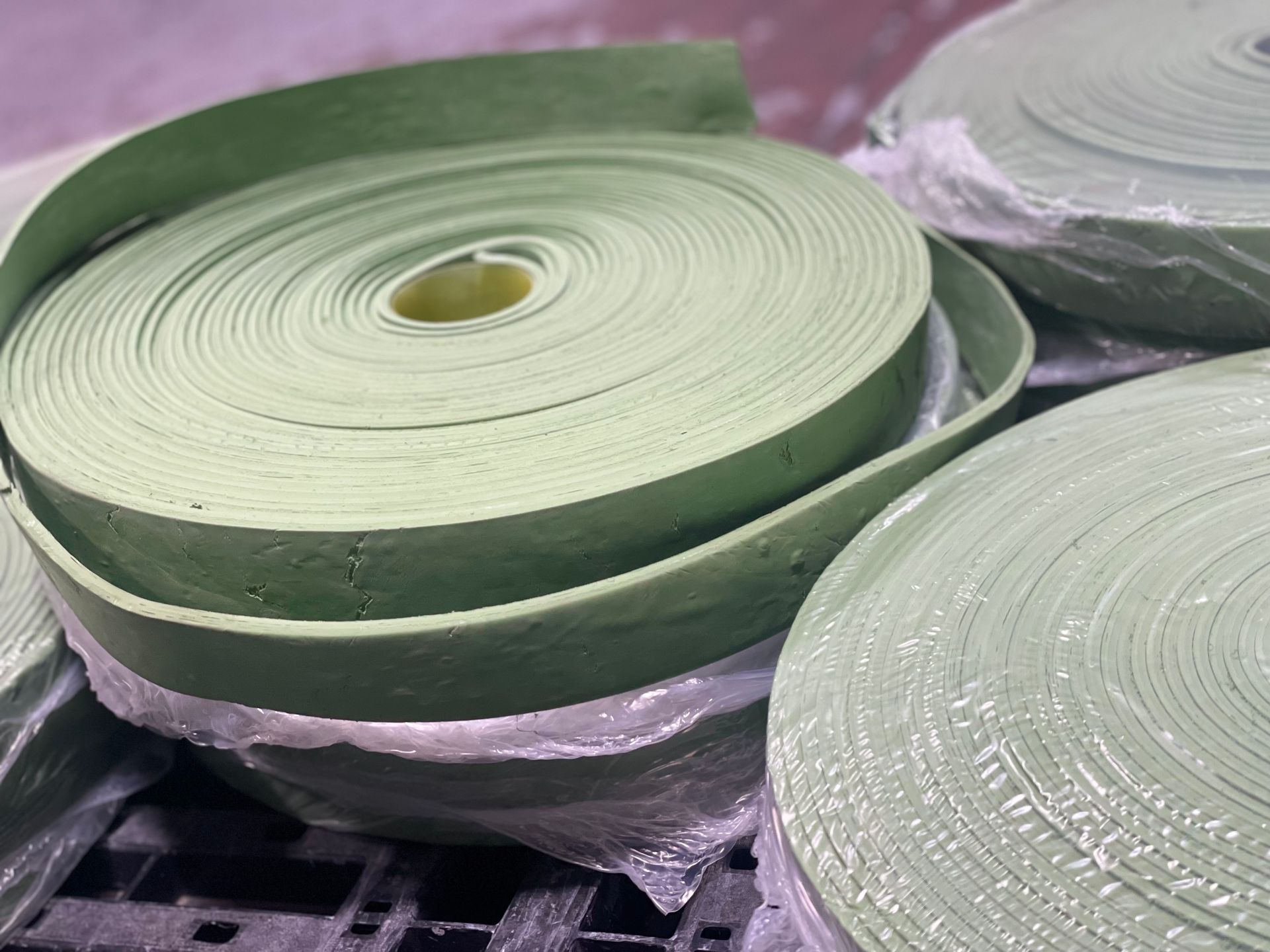 Bobine di filo o nastro verde chiaro impilate in pellicola di plastica
